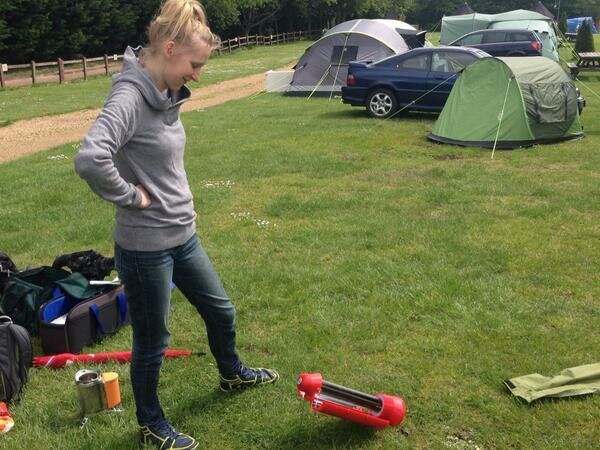 Red solar kettle being tested on a camp site